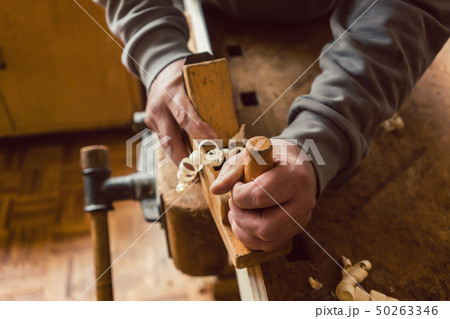 Top view of carpenter hand working with wood planer Top view of carpenter hand working with wood planer 50263346