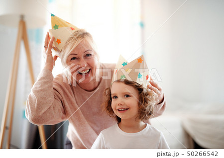 A portrait of small girl with grandmother at home, having fun. A portrait of small girl with grandmother at home, having fun. 50266542