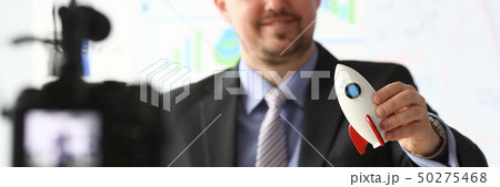 Businessman hold rocket in hand closeup Businessman hold rocket in hand closeup 50275468