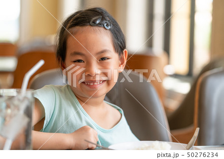Little Asian girl at food table Little Asian girl at food table 50276234