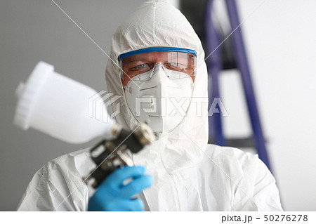 Workman hold in arm airbrush gun wearing protective suit Workman hold in arm airbrush gun wearing protective suit 50276278
