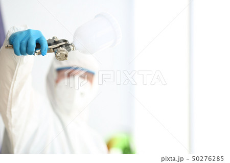 Workman hold in arm airbrush gun wearing protective suit Workman hold in arm airbrush gun wearing protective suit 50276285