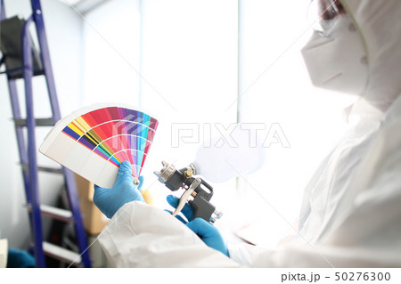 Hands of workman holding airbrush and colorful fantail picking wall 50276300