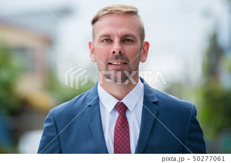 Head shot of happy businessman with blond hair smiling outdoors 50277061