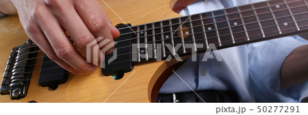 Male arms playing classic shape electric guitar 50277291