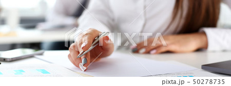 Female arm in suit hold silver pen and pad Female arm in suit hold silver pen and pad 50278735