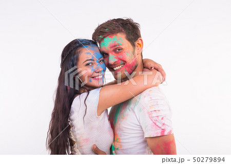 Holiday, holi and people concept - Smiling funny woman and man posing with multicolored powder on Holiday, holi and people concept - Smiling funny woman and man posing with multicolored powder on 50279894