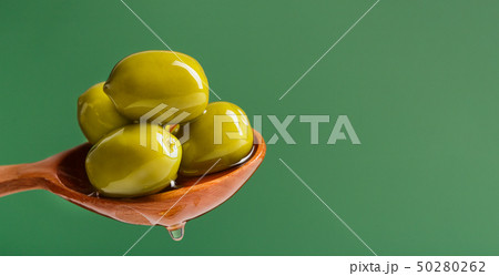 Green olives in spoon on green Green olives in spoon on green 50280262