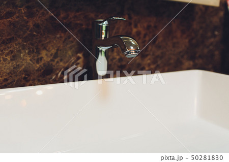 Bathroom interior with white sink and faucet. 50281830