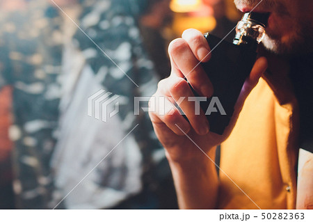 Man is smoking electronic cigarette or vaporizer. Man is smoking electronic cigarette or vaporizer. 50282363