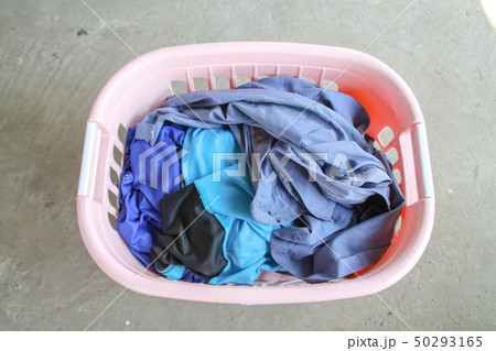 Pink Basket with dirty laundry on floor. Pink Basket with dirty laundry on floor. 50293165