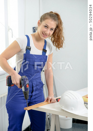 pretty young woman holding cordless drill pretty young woman holding cordless drill 50294034