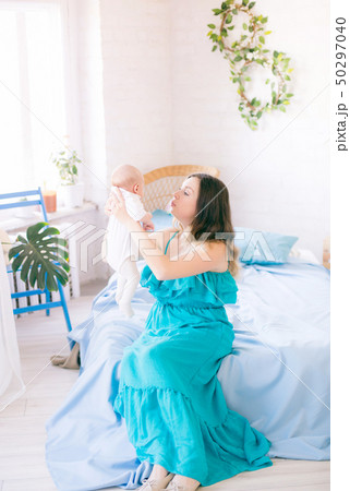 Young cute mom holding a baby in her arms Young cute mom holding a baby in her arms 50297040