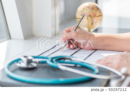 Physician doctor writing on medical health record 50297212