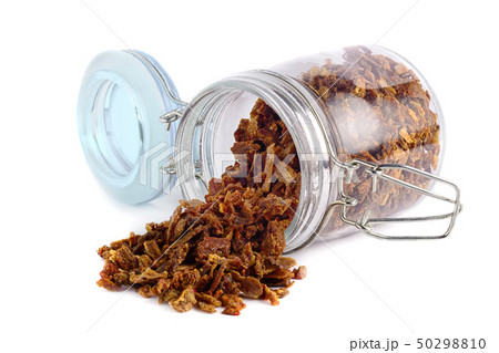 Propolis granules are scattered from a glass jar. 50298810