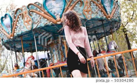 Girl chilling in amusement park in weekend morning. Laughing female model Girl chilling in amusement park in weekend morning. Laughing female model 50304280