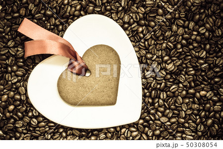Heart shaped cookie and plate on coffee beans Heart shaped cookie and plate on coffee beans 50308054