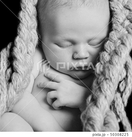 naked newborn baby sleeps curled up in a ball in a naked newborn baby sleeps curled up in a ball in a 50308225