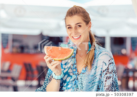 Woman holding piece of watermelon 50308397