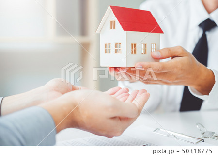 Sale agent giving house to customer and sign 50318775