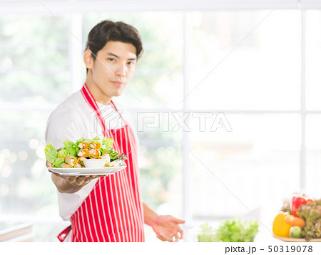 Asian man held a salad plate for the camera.. 50319078