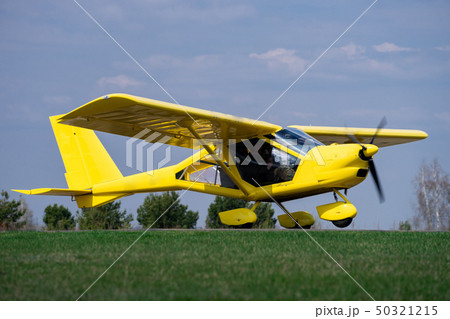 small yellow charter airplane waiting on a green field to take off small yellow charter airplane waiting on a green field to take off 50321215