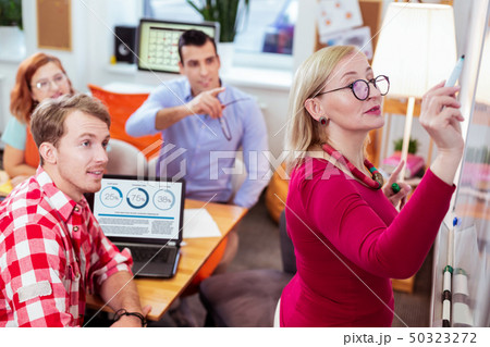 Positive smart woman writing a rule on the board Positive smart woman writing a rule on the board 50323272