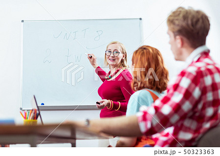 Joyful friendly woman holding a market in her hand 50323363