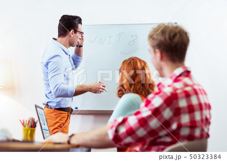 Serious young teacher conducting a group lesson Serious young teacher conducting a group lesson 50323384