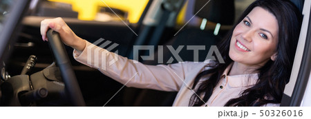 Happy customer woman buying a new car in dealeship center Happy customer woman buying a new car in dealeship center 50326016