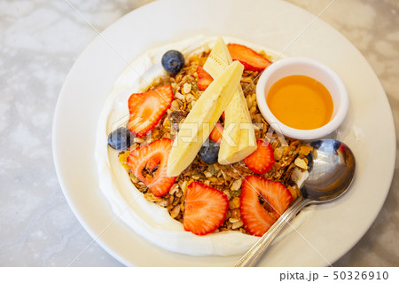 Homemade granola with yogurt and mixed fruits and honey from top view. 50326910