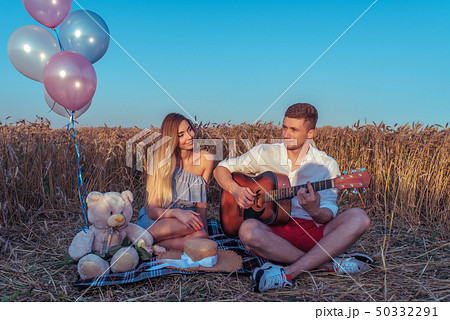 Happy young couple, man woman, sitting plaid summer. Wheat field, outdoor recreation village 50332291