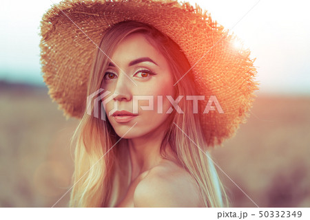 Closeup portrait, beautiful woman straw hat. In the summer on the nature of the tanned girl with 50332349