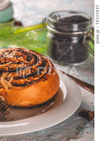 Glass full of poppy seads behind sweet baked bun Glass full of poppy seads behind sweet baked bun 50332935