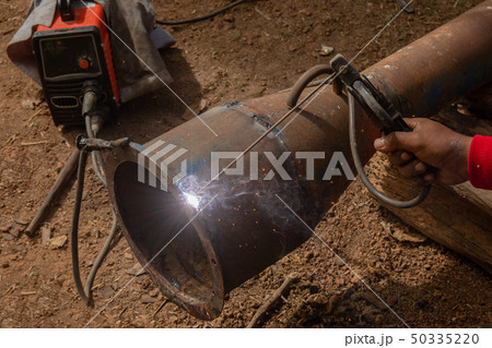 Welder is welding metal piping in construction Welder is welding metal piping in construction 50335220