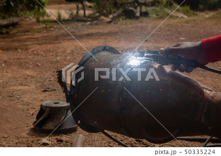 Welder is welding metal piping in construction 50335224