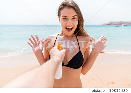 Man's hand is suddenly applying suntan lotion on Man's hand is suddenly applying suntan lotion on 50335489