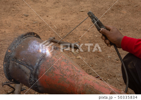 Welder is welding metal piping in construction Welder is welding metal piping in construction 50335834