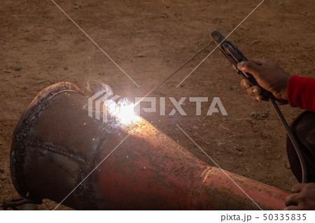 Welder is welding metal piping in construction Welder is welding metal piping in construction 50335835