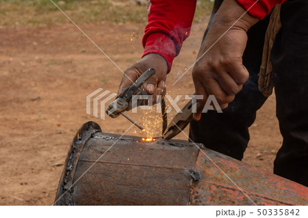 Welder is welding metal piping in construction Welder is welding metal piping in construction 50335842
