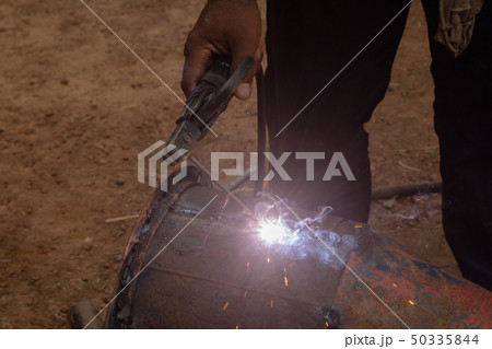 Welder is welding metal piping in construction 50335844