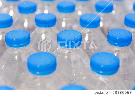 Row of water bottles. Bottles with blue caps For 50336068