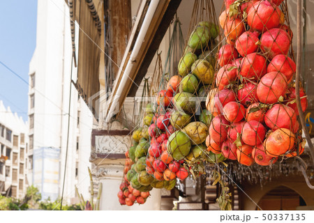 Mango and pomegranates in woven bags. 50337135