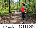 Fitness woman doing leg stretching before run in forest 50338064