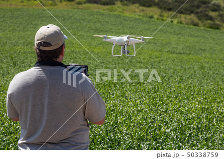 UAV Drone Pilot Flying and Gathering Data in Field 50338759