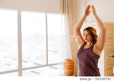 Attractive young woman raising her hands up Attractive young woman raising her hands up 50338792