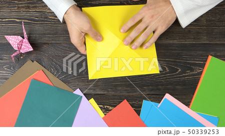 Man folding paper as triangle. Man folding paper as triangle. 50339253