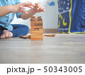 Small kid playing with wooden blocks on the floor 50343005