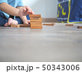 Small kid playing with wooden blocks on the floor 50343006