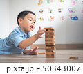 Small kid playing with wooden blocks on the floor 50343007